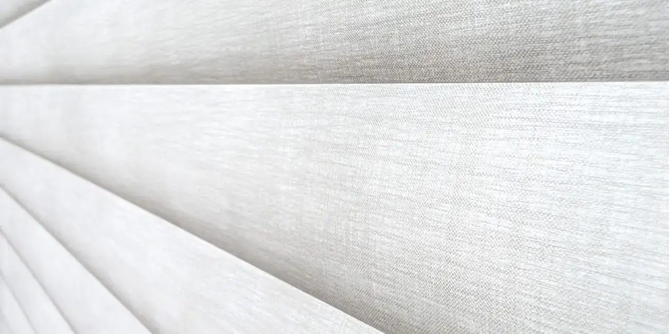 Light-colored Sonnette® roller shades made of soft fabric, providing elegant window coverage and light control. Perfect for modern home decor.