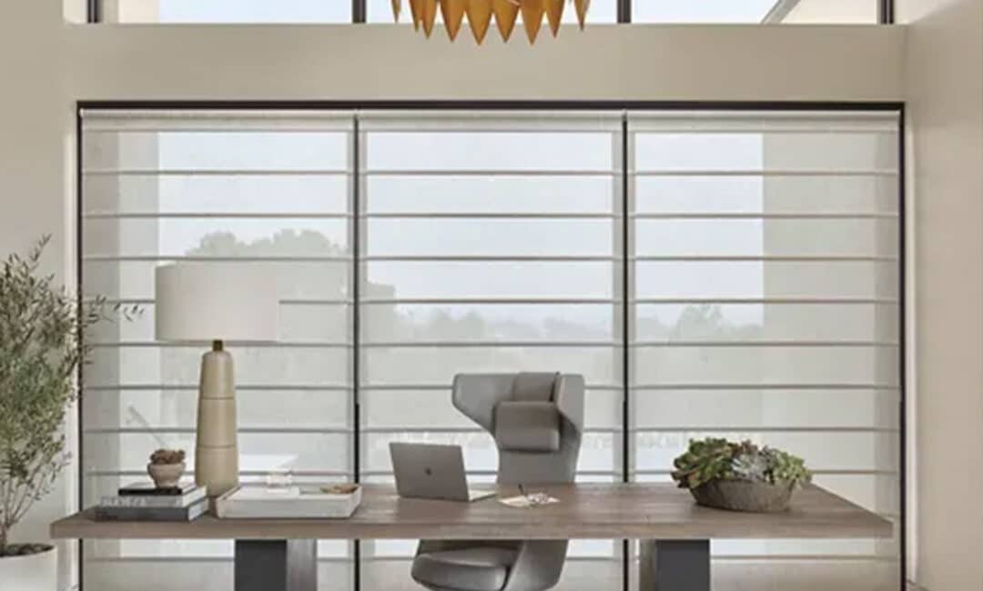 Bright modern office featuring large windows, sleek desk, ergonomic chair, and contemporary decor for a productive workspace.