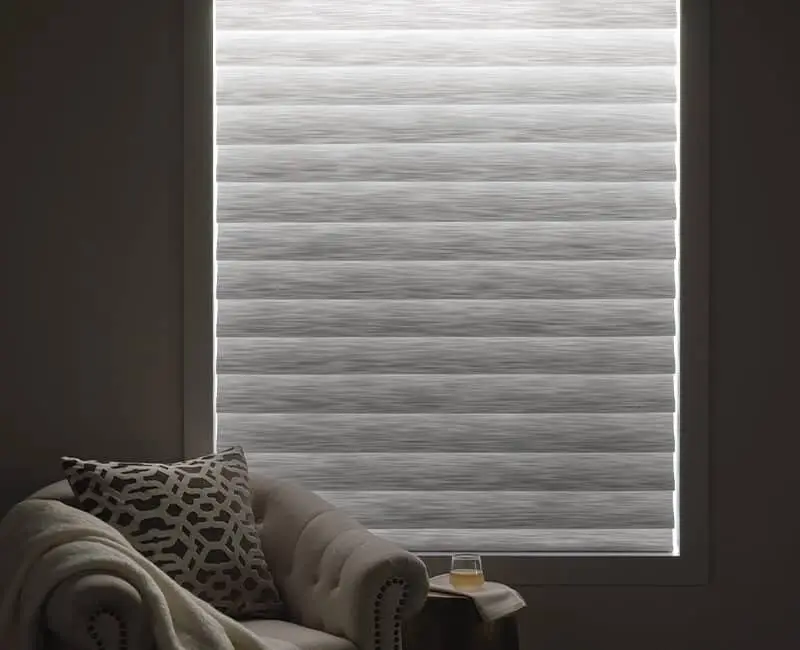 Bright, modern window blind with horizontal stripes controlling natural light, creating a calm and inviting atmosphere inside the living room.