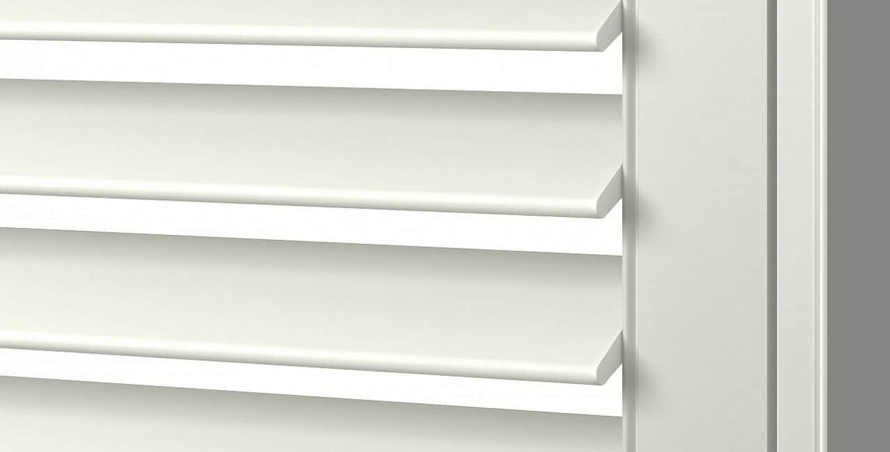 Close-up of white vinyl plantation shutters with adjustable louvers for light control and aesthetics.