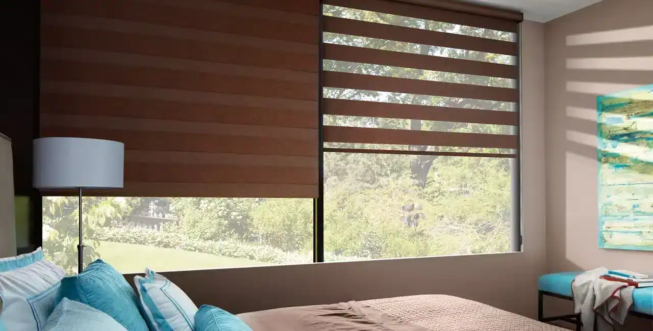 Bright hotel room with modern window blinds, blue bedding, and scenic outdoor view.