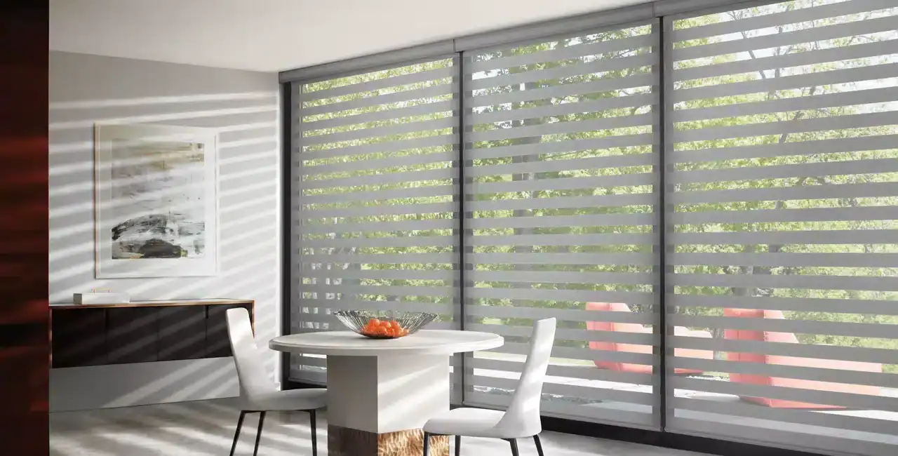 Bright, modern dining space with elegant zebra blinds on large glass sliding doors, enhancing natural light and privacy. Minimalist decor with white table and chairs, perfect for contemporary homes.