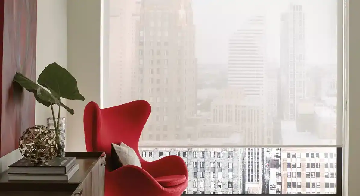 Stylish interior with a bright red lounge chair, modern decor, large balcony window, and city skyline background.