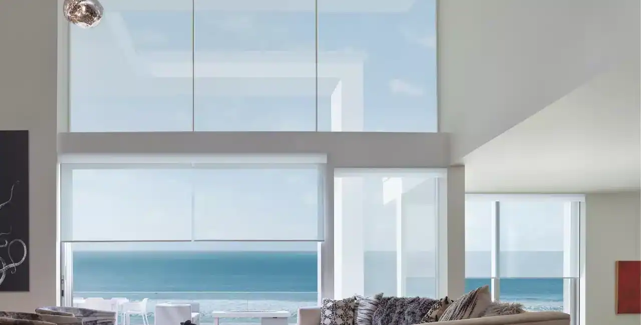 Bright, airy coastal living room with large windows offering ocean views.