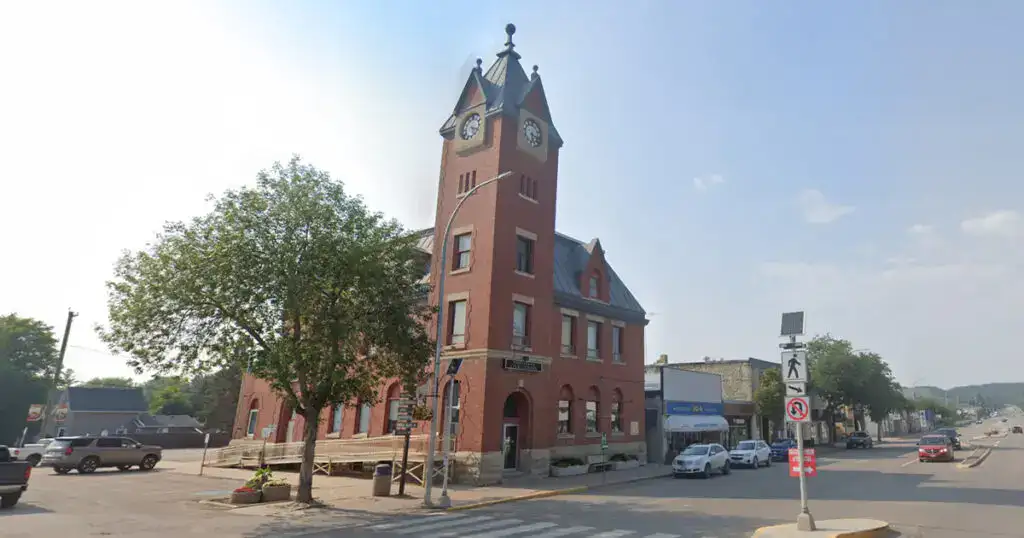 Iconic red brick Minnedosa Town Hall with clock tower in downtown Minnedosa, Manitoba, showcasing historic architecture and local heritage.