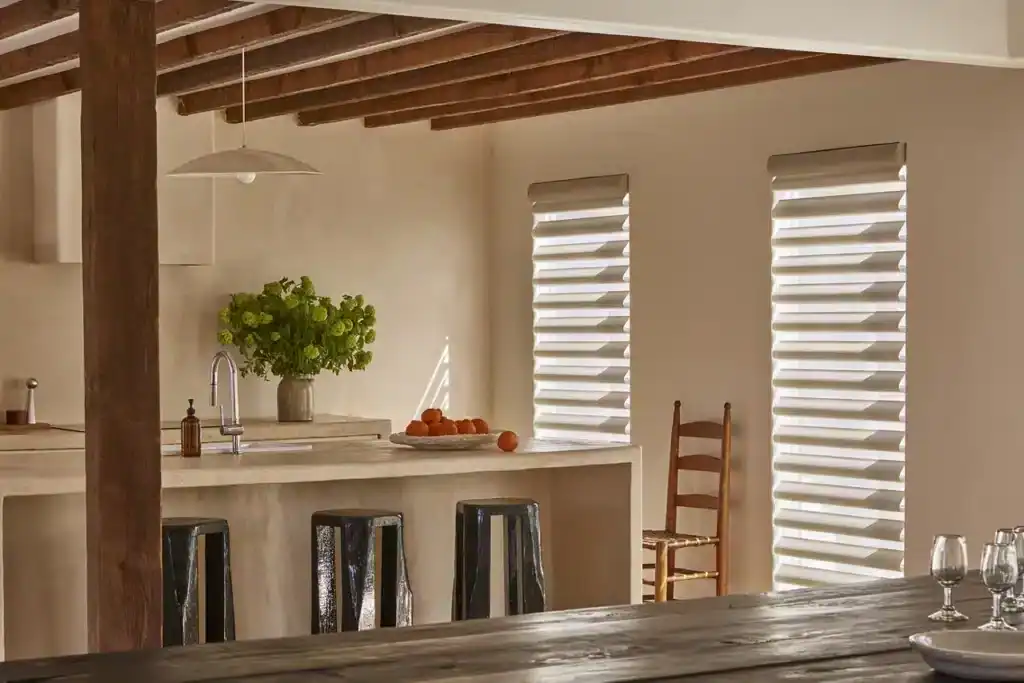 Bright and airy kitchen featuring white walls, wooden ceiling beams, and stylish window blinds. Perfect for contemporary home design.