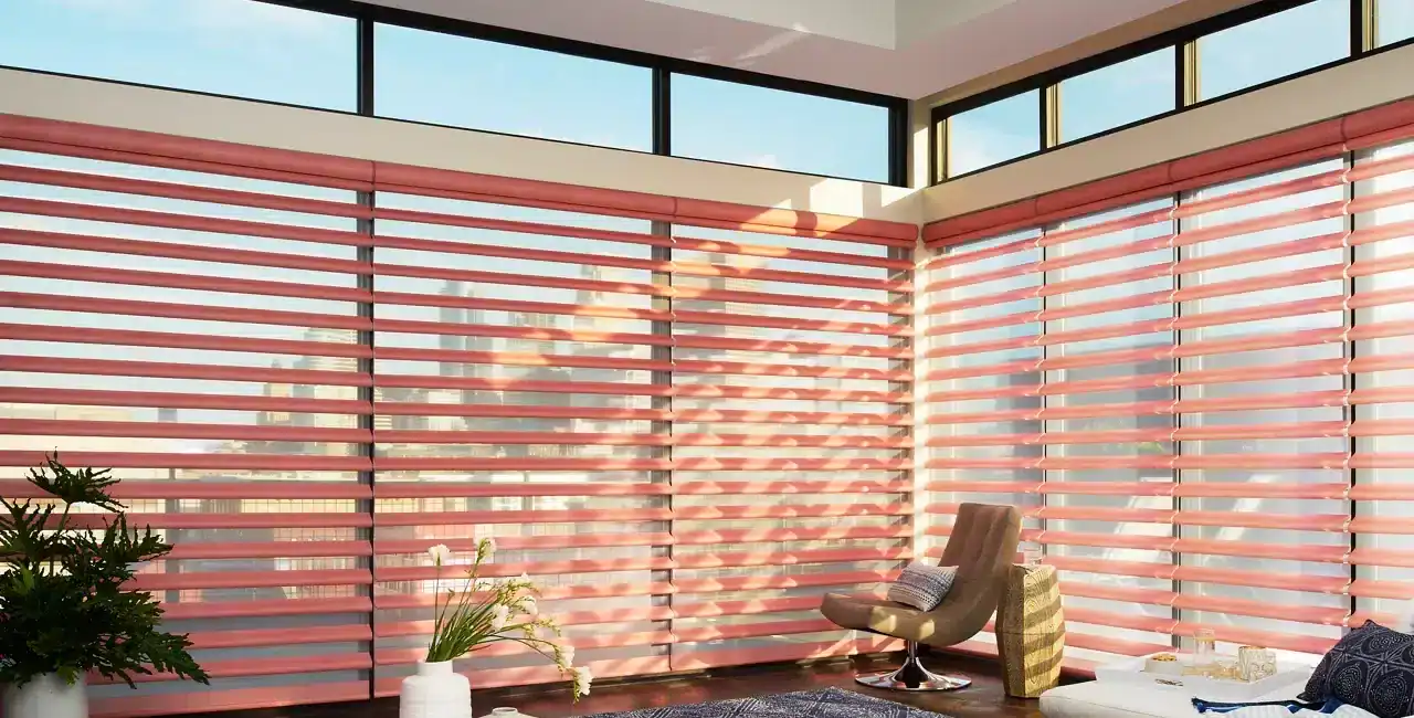 Bright living space with large windows and pink blinds, showcasing modern decor, comfortable seating, and cityscape exposure for a relaxed, contemporary atmosphere.