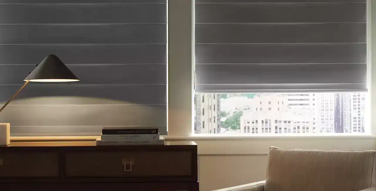 Stylish window blinds letting in natural light, modern furniture, comfortable armchair, home decor, urban view, relaxing interior, contemporary design, bright space, minimalistic style.