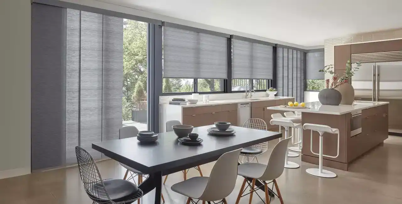 Bright, airy kitchen featuring gray roller shades, minimalist design, and contemporary furniture with a spacious dining area.