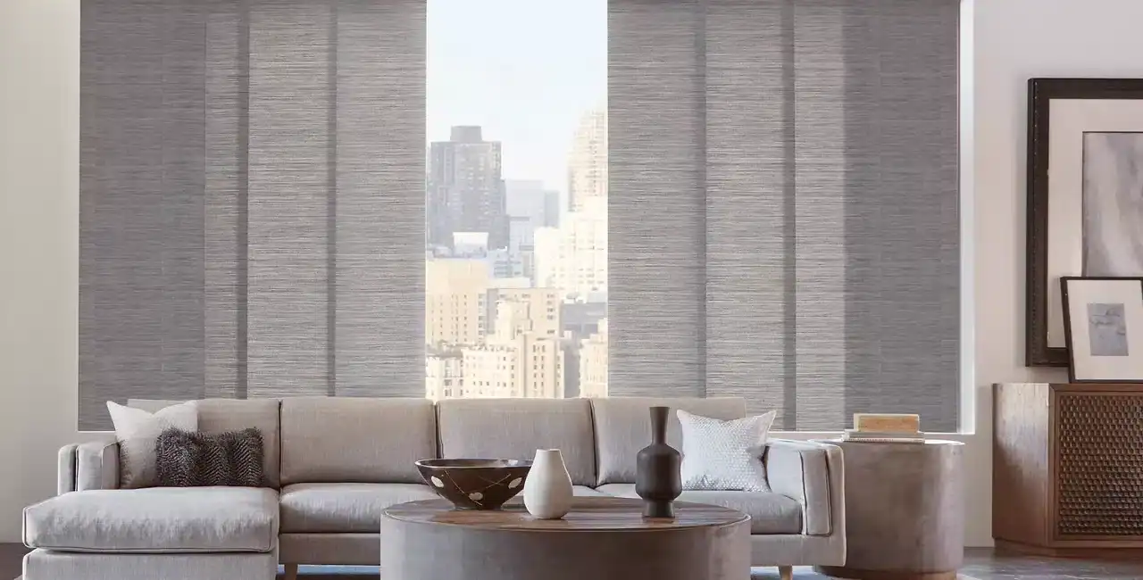 Bright living room with large cityscape window, neutral-toned sofa, contemporary decor, and stylish accessories for urban home design.