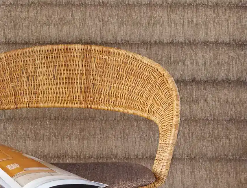 Comfortable wicker chair with curved backrest and cushions.
