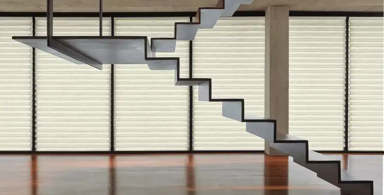 Staircase with minimalist black and white design against concrete wall and large windows, showcasing modern architecture and clean lines.