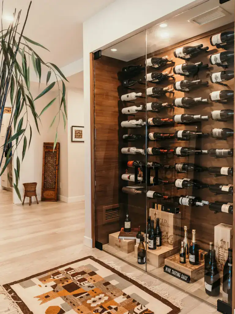 Elegant wine storage with glass door, showcasing a variety of wine bottles in a stylish interior setting.