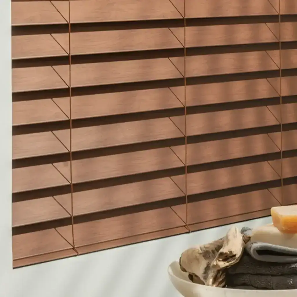 Wooden window blinds with horizontal slats, showcasing natural wood texture and warm tones, paired with a decorative stone arrangement on a white surface for aesthetic appeal.