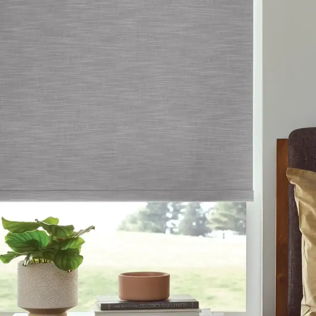 Contemporary gray roller blind covering a window in a modern living room, providing privacy and style with a sleek, minimalist design.