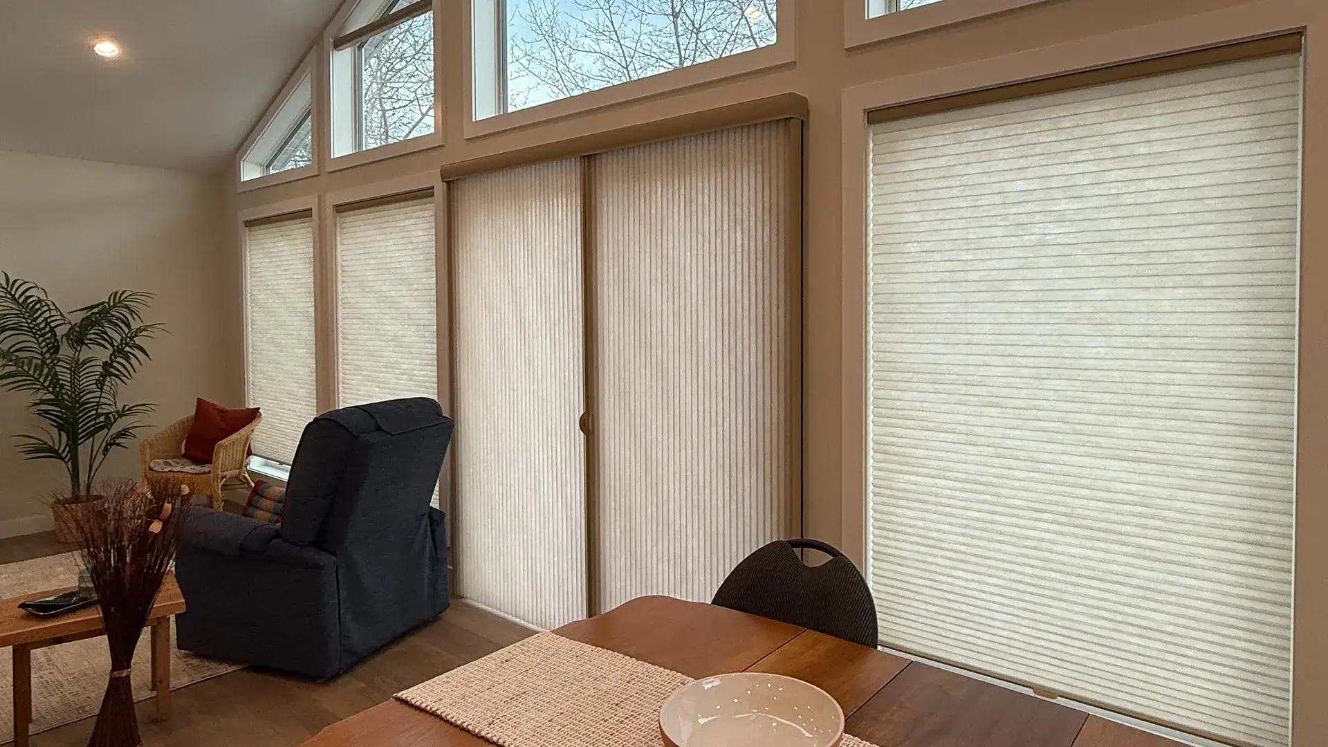 Modern interior with Vertiglide™ window blinds, large windows, natural light, cozy seating area, home decor, contemporary style, privacy solutions, sunlight control, elegant design, residential space.